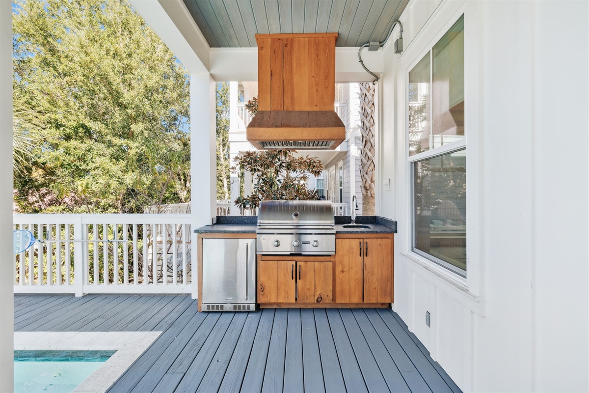 Private outdoor pool area conveniently located just outside the living room and kitchen, featuring a heated pool with a beautiful waterfall, seating and loungers, plus an outdoor grill and kitchenette