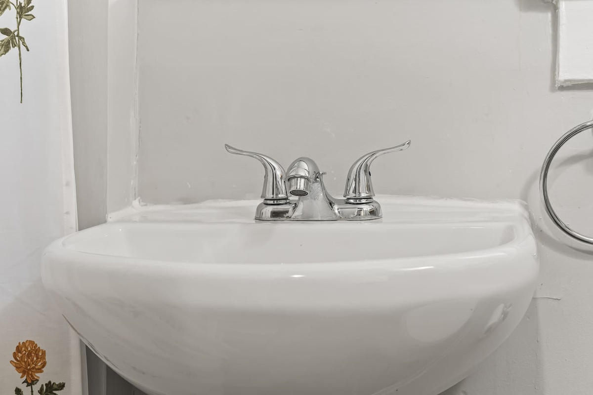 A classic pedestal sink with polished fixtures adds a tidy finishing touch.