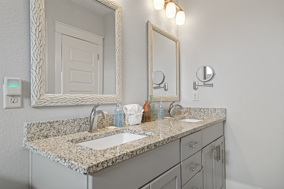 Grand Master ensuite vanity with granite countertop and upgraded lighting.