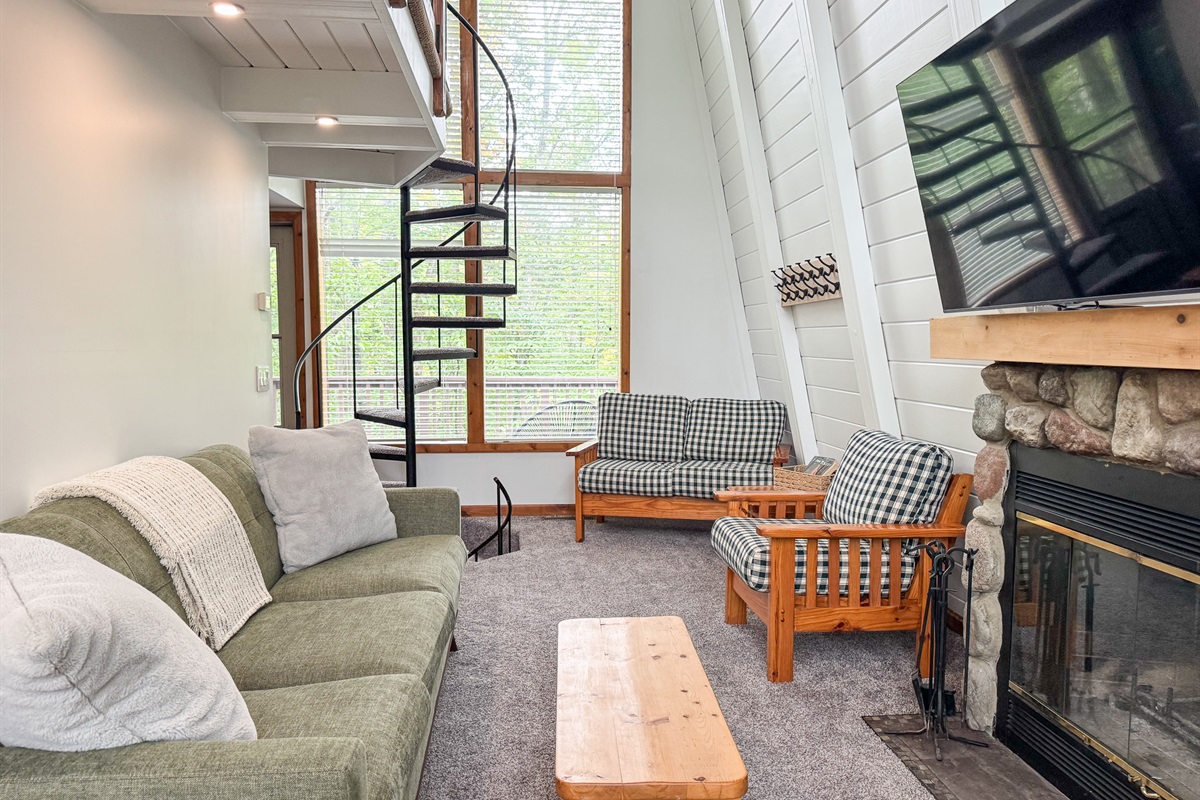 Cozy living room with natural log fireplace and flatscreen tv with streaming