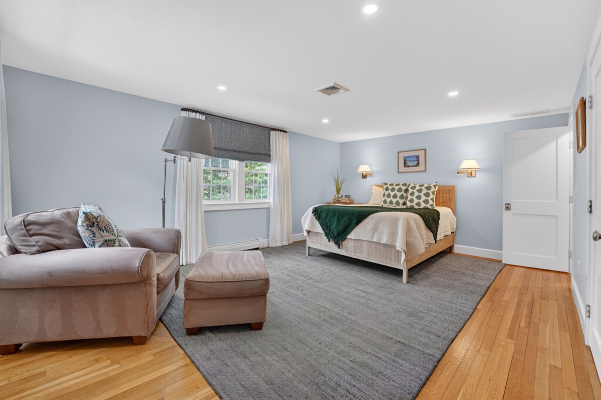 A warm third bedroom with a queen bed and a comfy solo couch for extra relaxation!