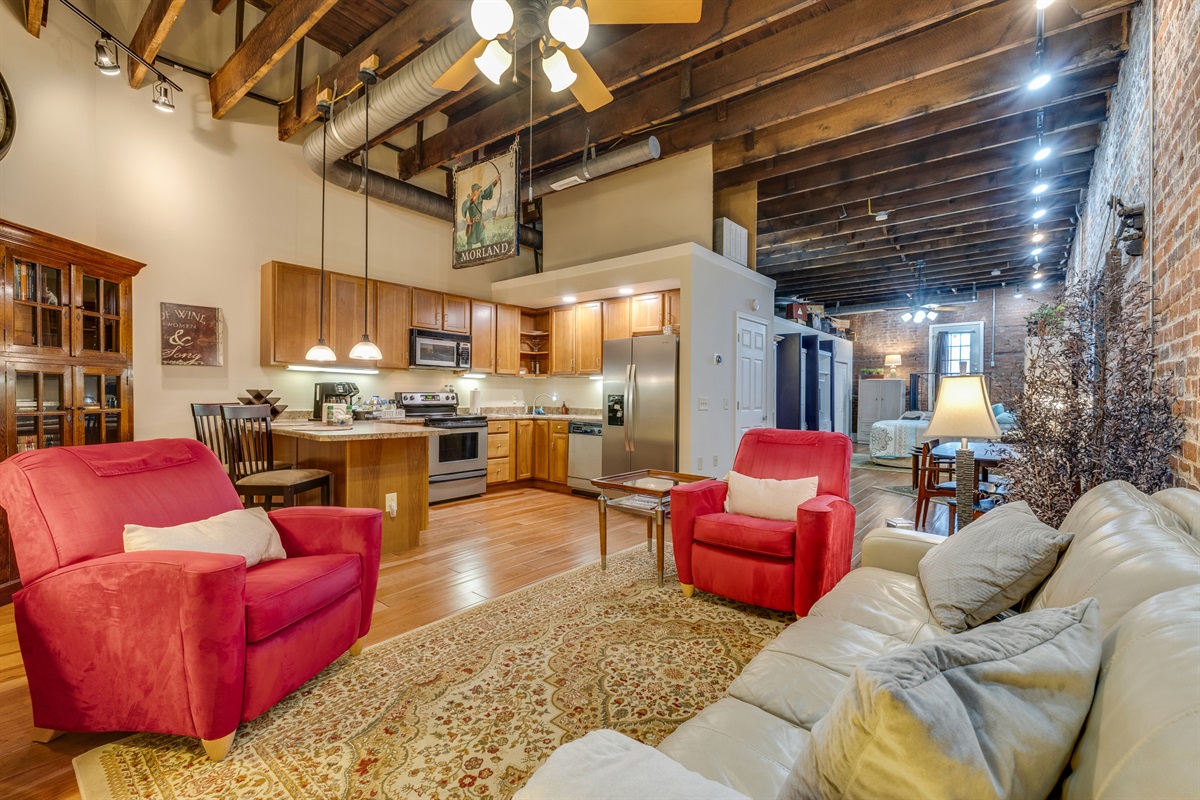 The sitting area of the kitchen and bar features stainless steel appliances and custom hickory cabinets.