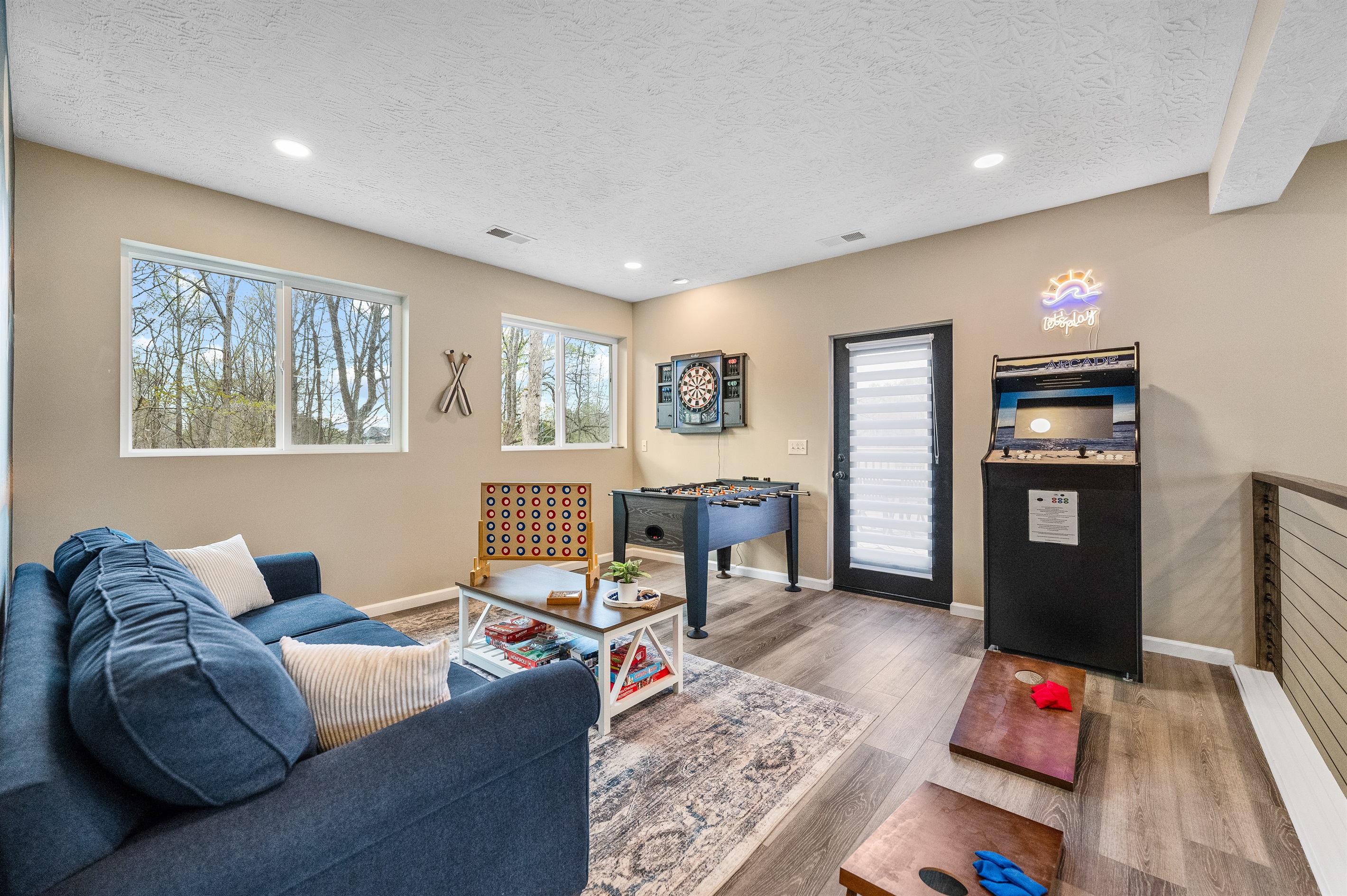 Giant Connect 4 and mini cornhole sets, conveniently stored in bags under the foosball table when not in use.  Step through the loft door onto the side deck, featuring a patio table for 10.