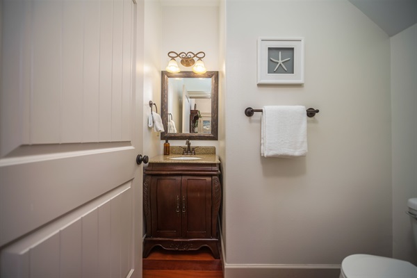 A half bathroom is located on the main floor adjacent to the living room for your convenience. This thoughtful design feature enhances guest comfort and provides a private space to freshen up during your visit without needing to go upstairs. 