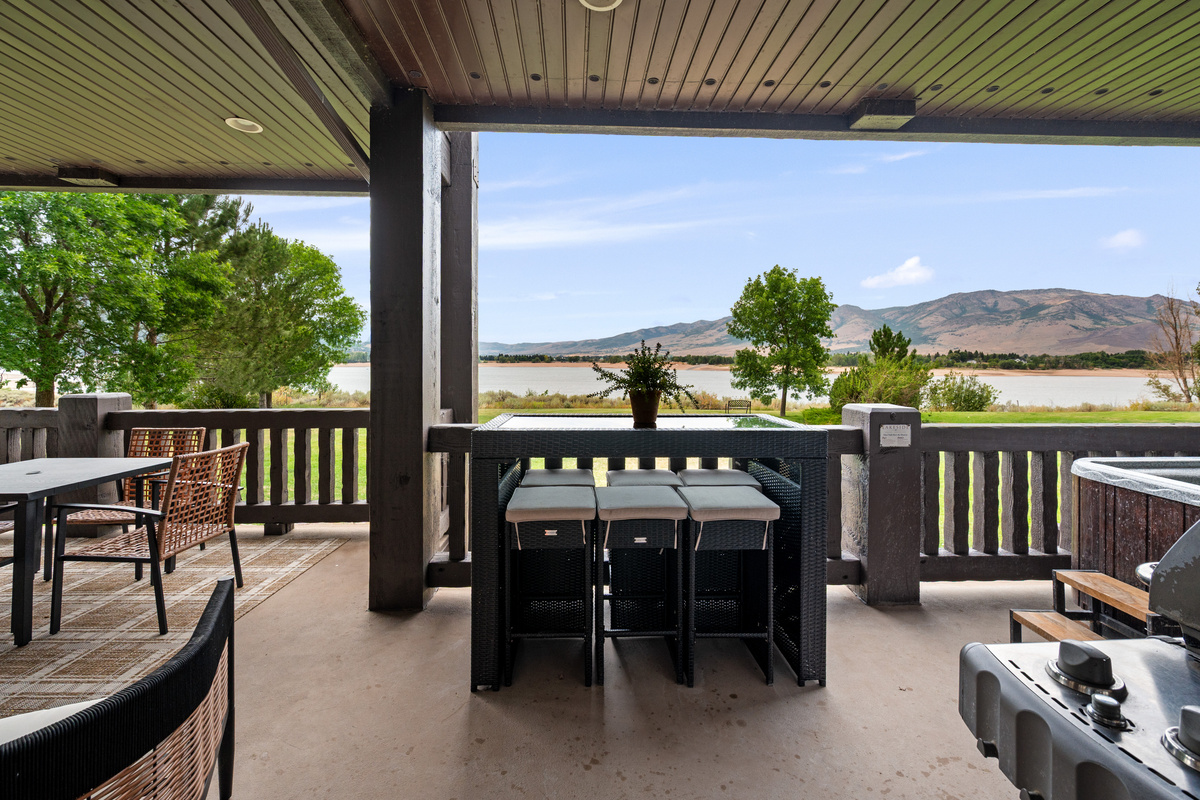 Spacious balcony brings together outdoor dining, lake views, a BBQ grill, and private hot tub.