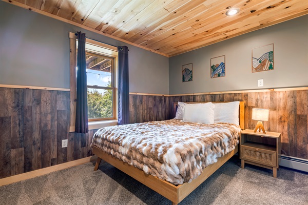 Extra sleeping space downstairs with a queen bed and attached bunk room.