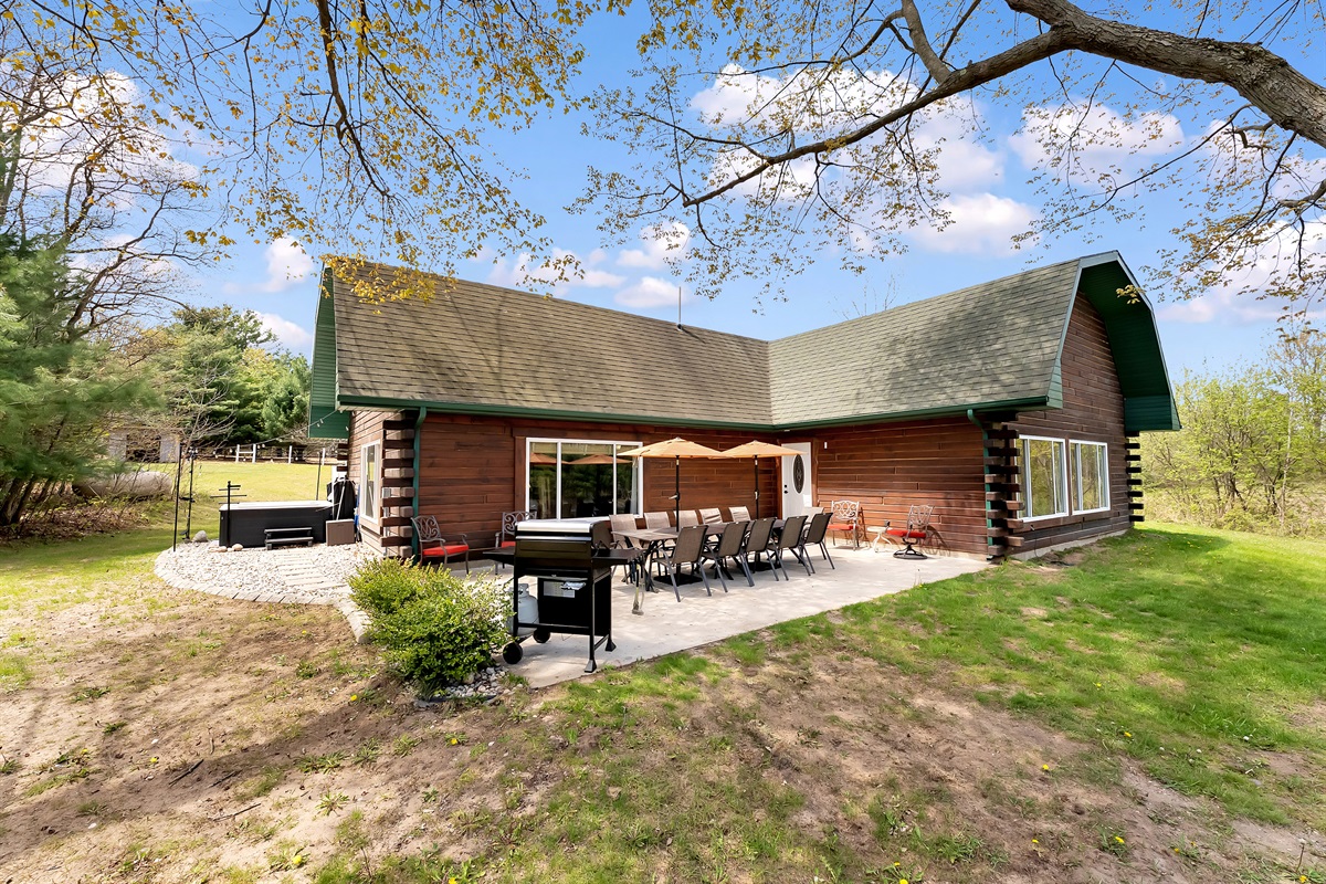 View of grill, outdoor seating area and hot tub.