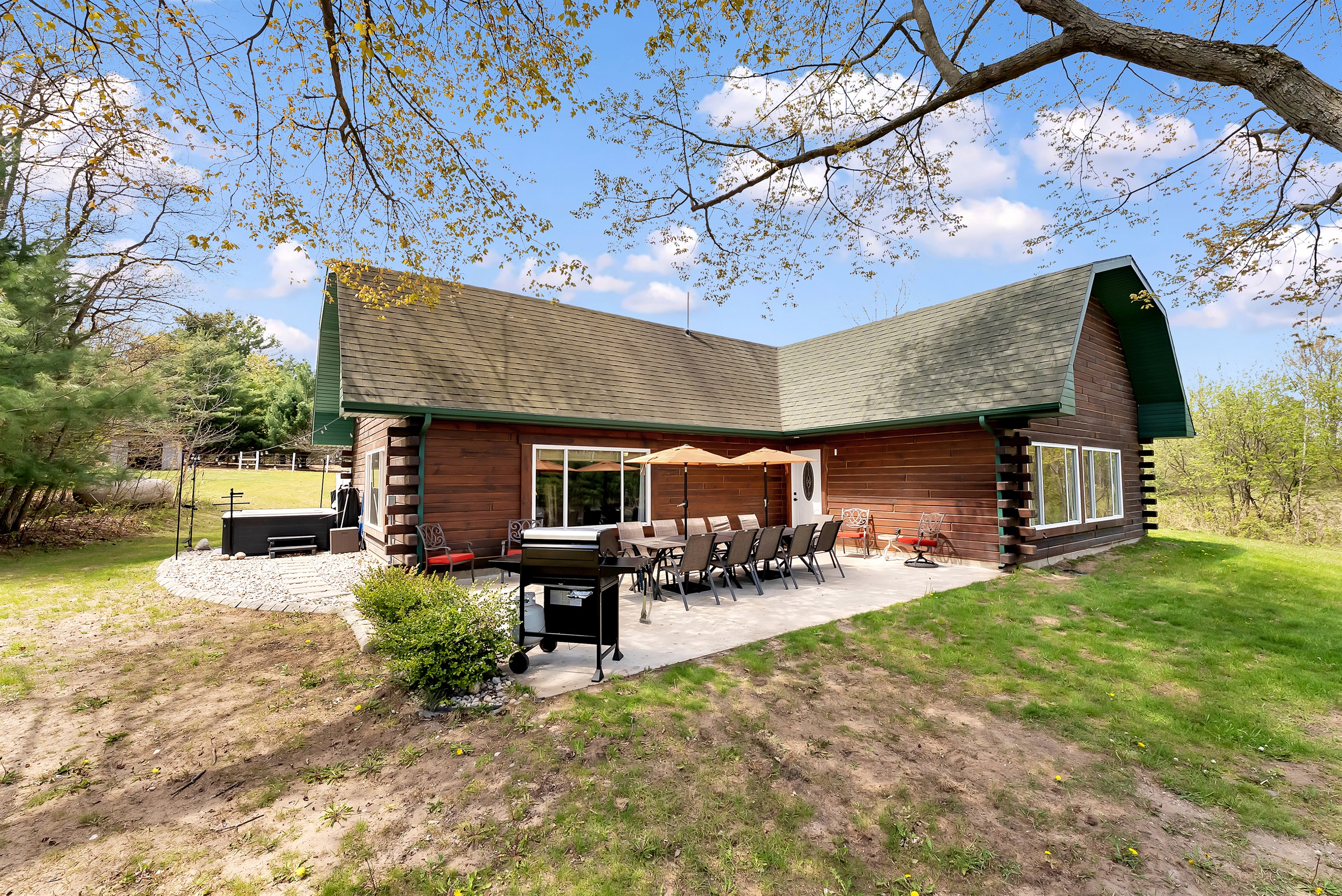 View of grill, outdoor seating area and hot tub.
