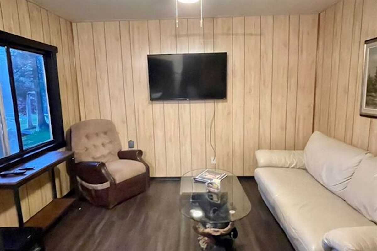 Cozy living room with sofa, armchair and wall-mounted TV
