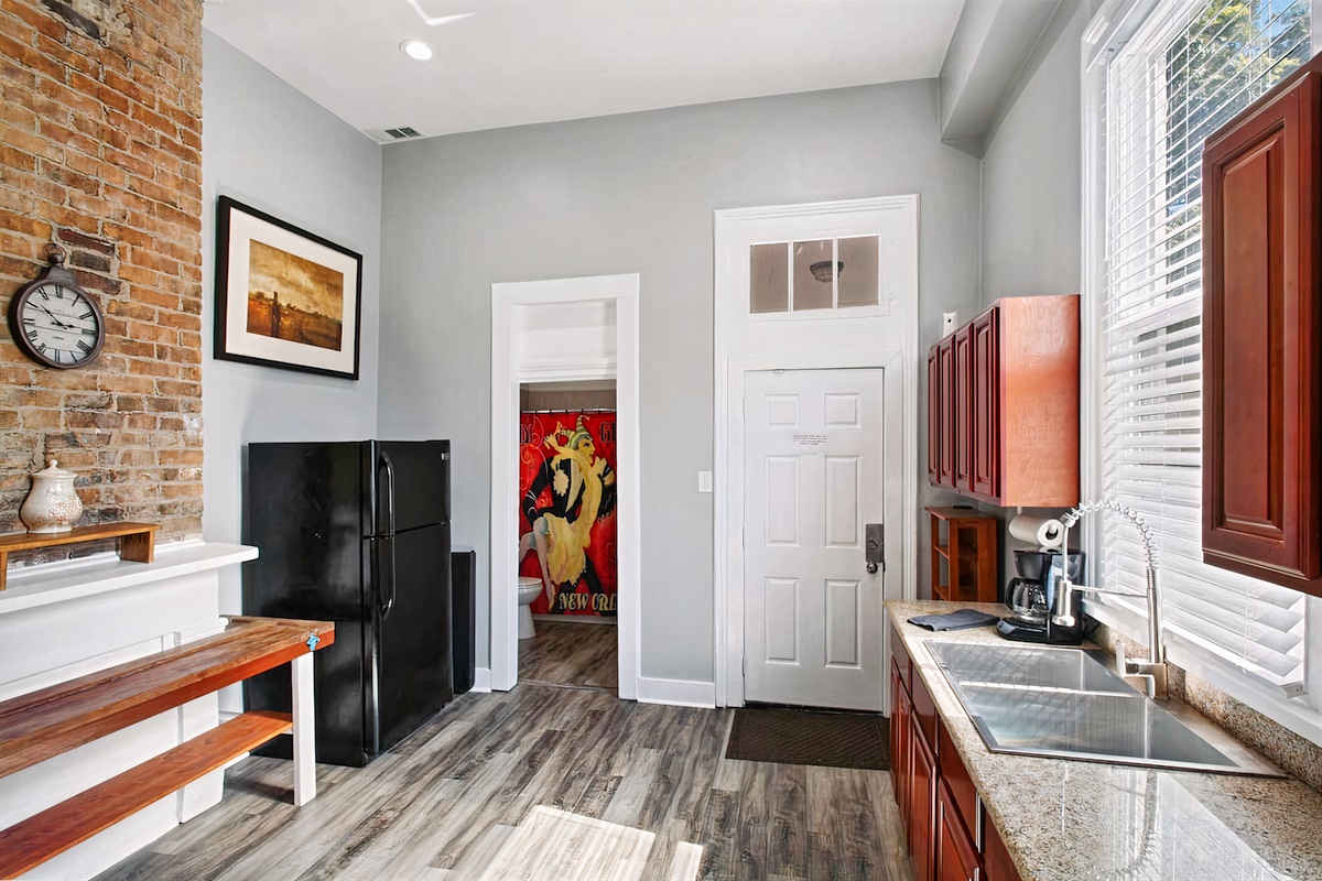 Full kitchen - doors to backyard and full bathroom; original 100+ year old brickwork