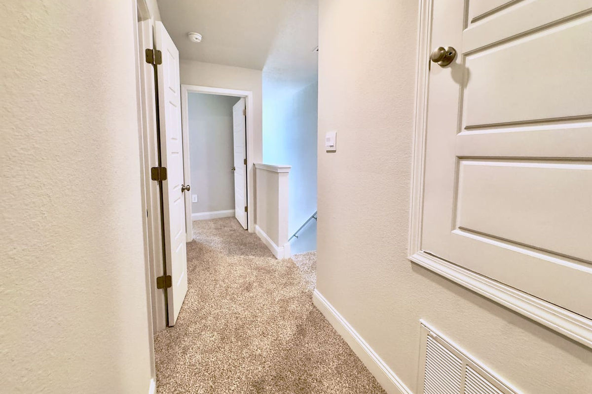 Quiet upstairs hallway, easy to move between rooms. Simple, tidy, effortless to navigate.