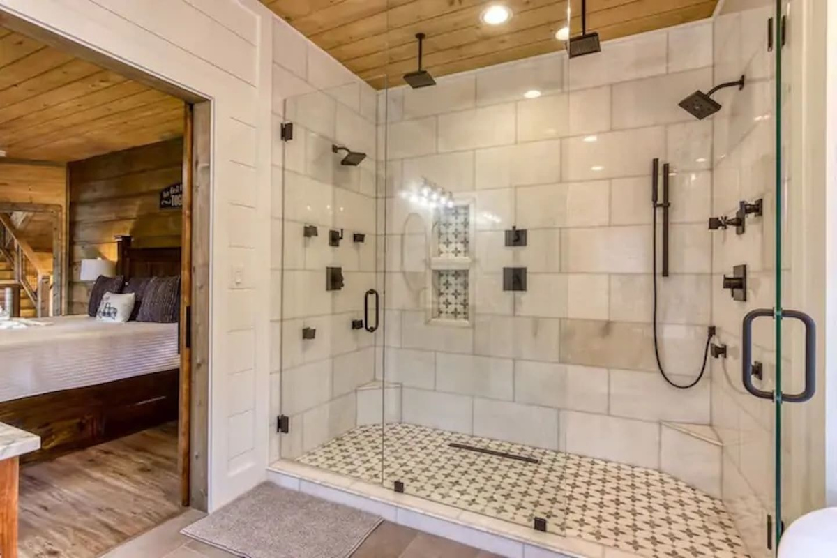 Master bathroom oversized spa-style shower featuring two rainfall heads, multi body sprays, and floor to ceiling marble tile