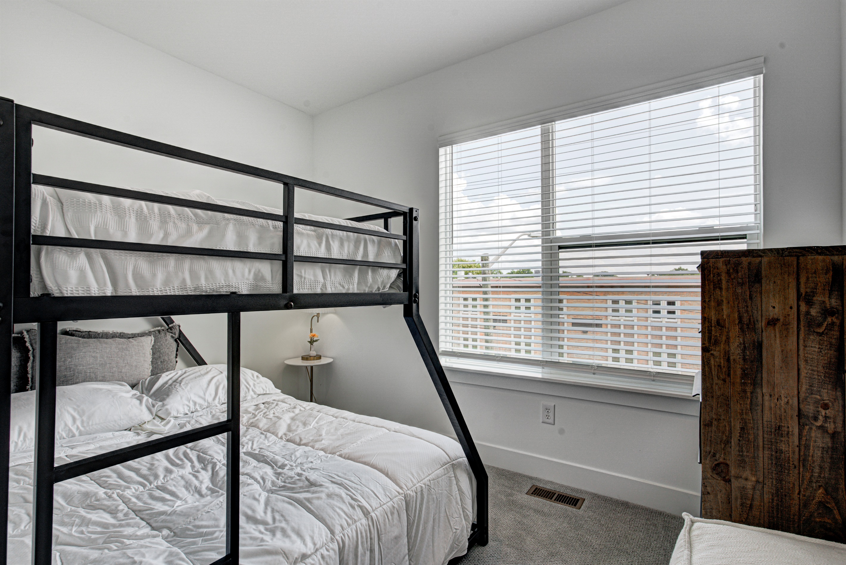 Relax in the serene bedroom featuring a comfortable king-size bed, soft linens, and cozy pillows. Includes nightstands, lamps, walk-in closet, and full-length mirror for added comfort.