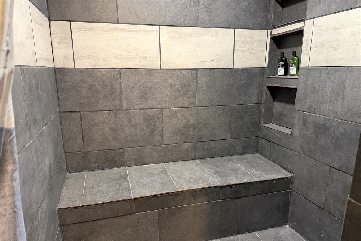 The large tile shower is accessible-friendly.