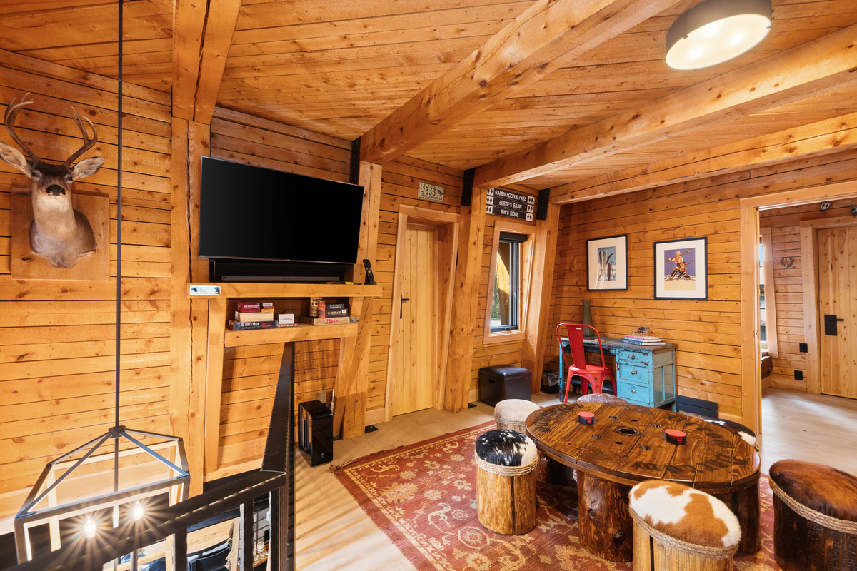 Multi-function second living area at top of stairs in the center of the upper level with game table, desk and tv and bathroom. 