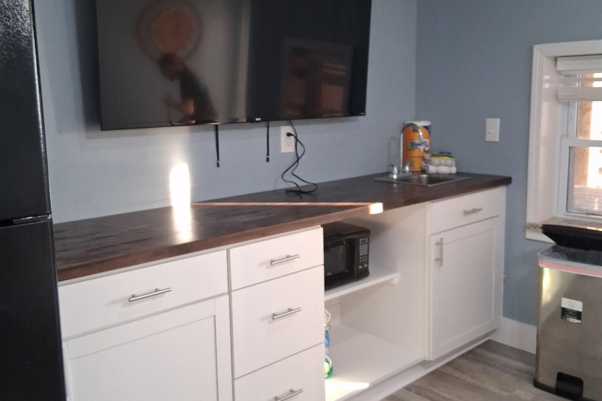 The 1st Floor features another Living Room w/ 65" Smart TV, Leather Sleeper Sofa, Multi-Game Arcade Console, a Kitchenette, and Beachfront Patio Access - Great for the Kids!