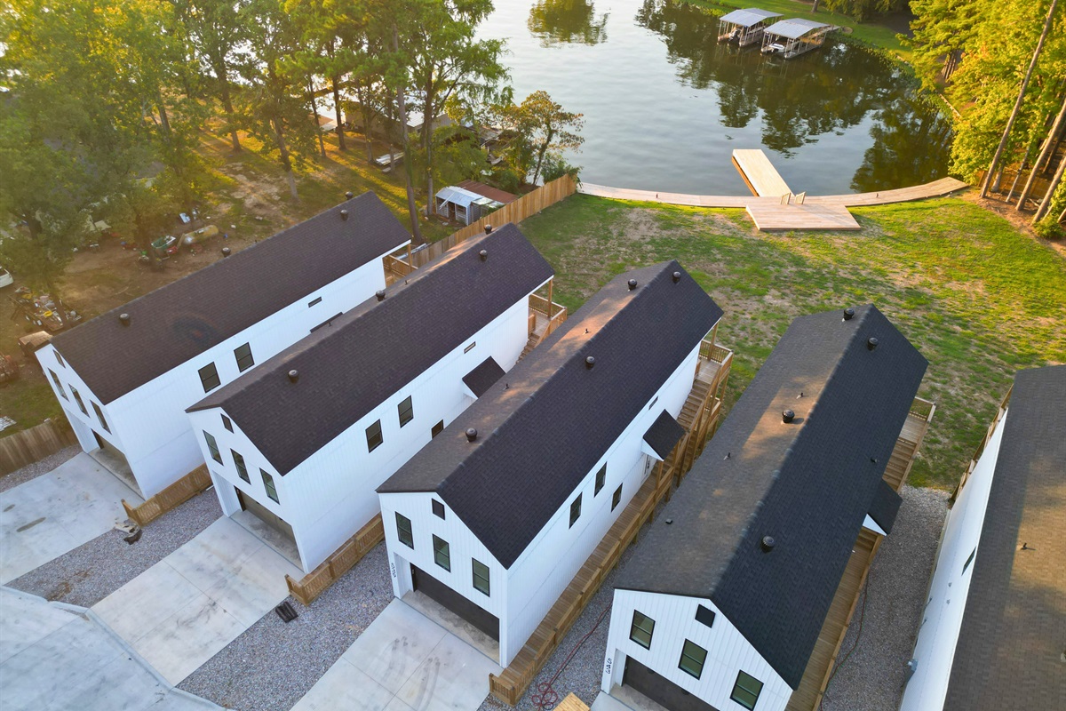 An aerial view shows the home&rsquo;s position along the shoreline and nearby dock access.