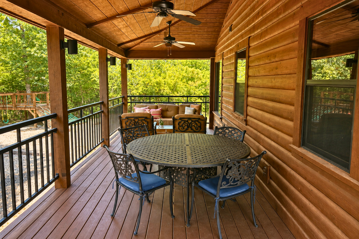 Meals can easily move outdoors at this covered dining table, where the surrounding greenery gives every breakfast or dinner a peaceful cabin backdrop.