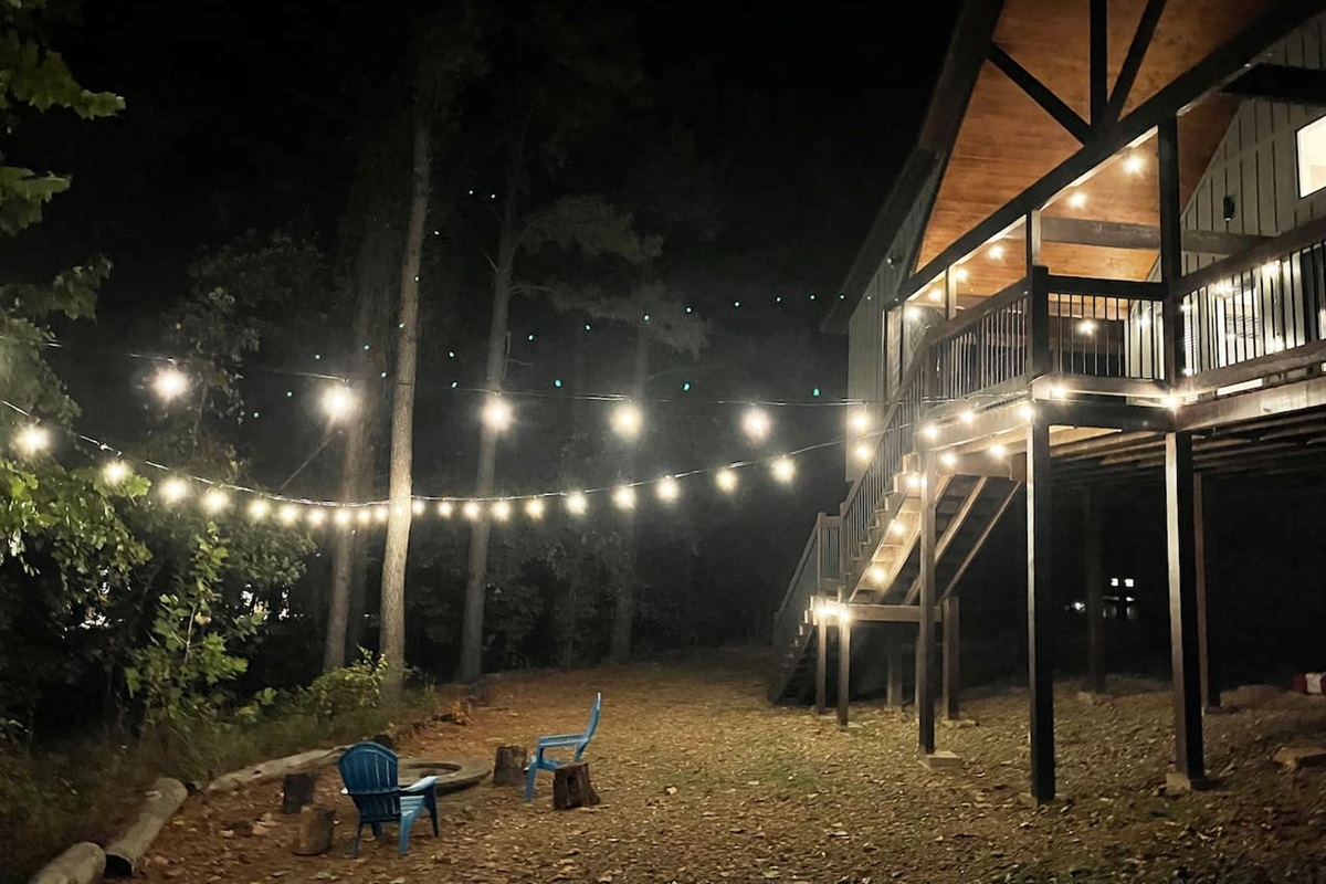 Overhead party lights provide subtle lighting for the back yard and fire pit area.