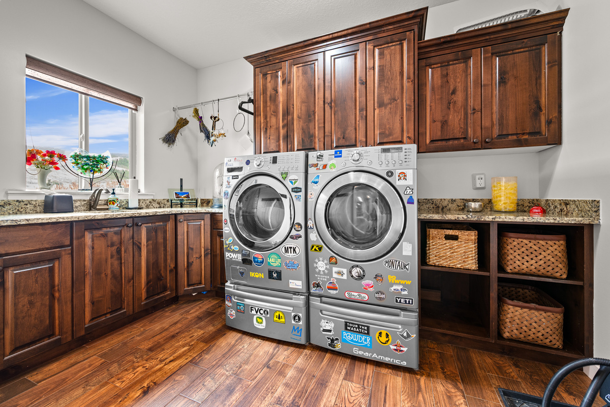 Spacious laundry room with washer, dryer, storage cabinets, and a boot warmer for winter adventures.