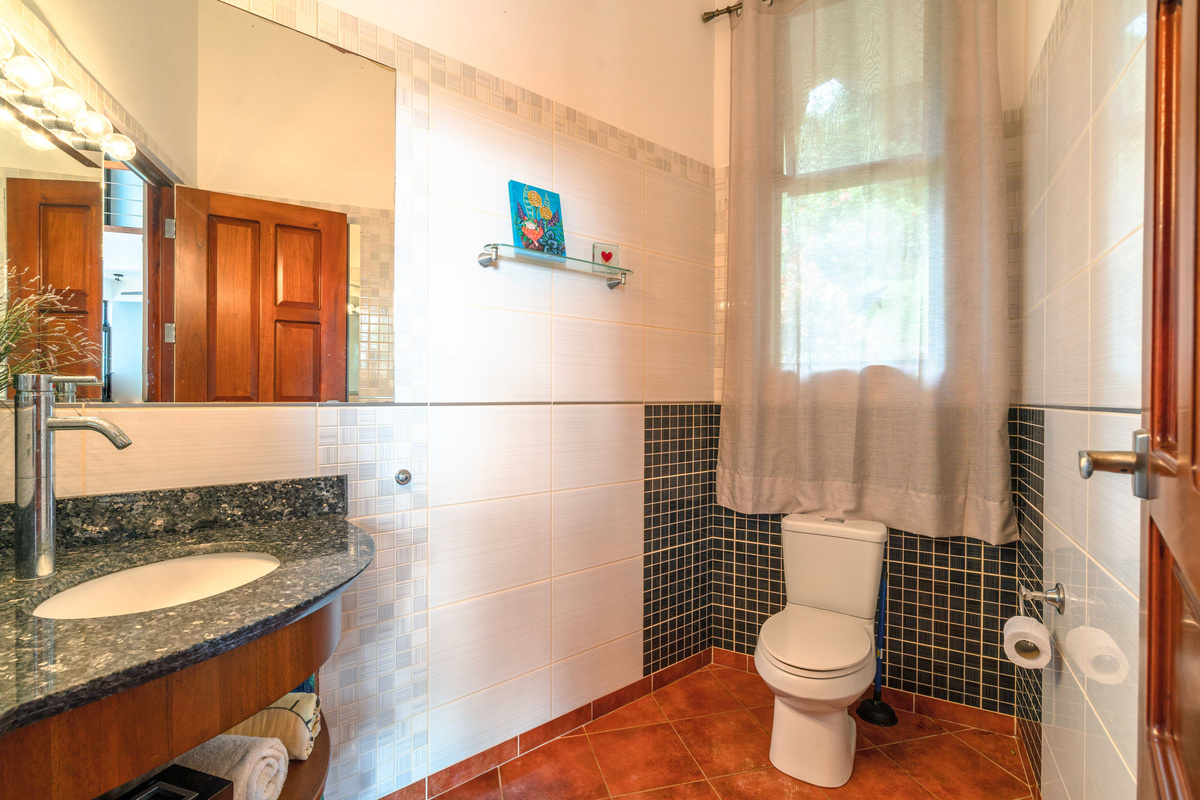 Private ensuite bathroom with stone vanity and garden window