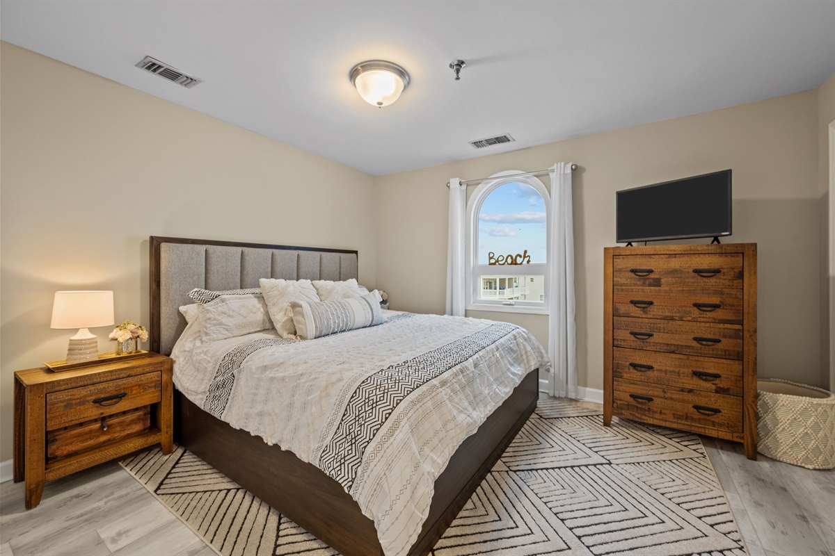 Spacious master bedroom with a plush King bed, elegant d&eacute;cor, and plenty of natural light for a restful retreat