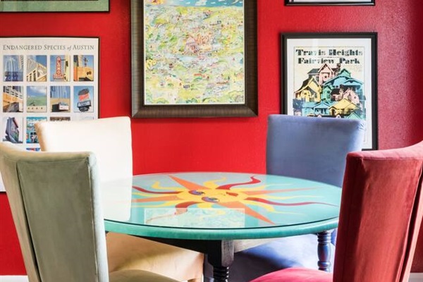 Gather around the hand-painted dining table in the bold, cherry-red dining space.