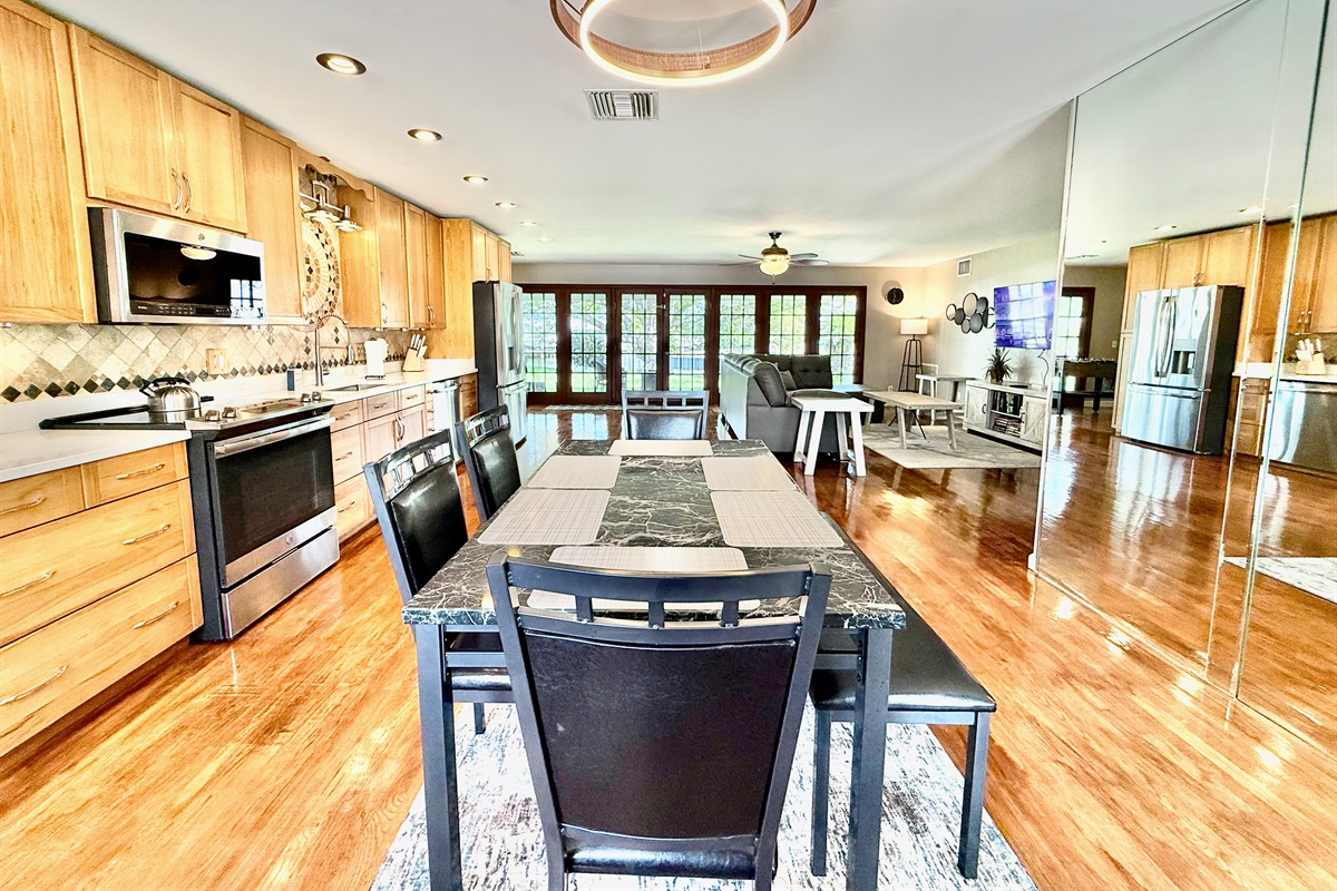 Share stories, laughs, and delicious meals at this sleek dining table, set in the heart of the home and surrounded by warm wood tones and modern lighting.