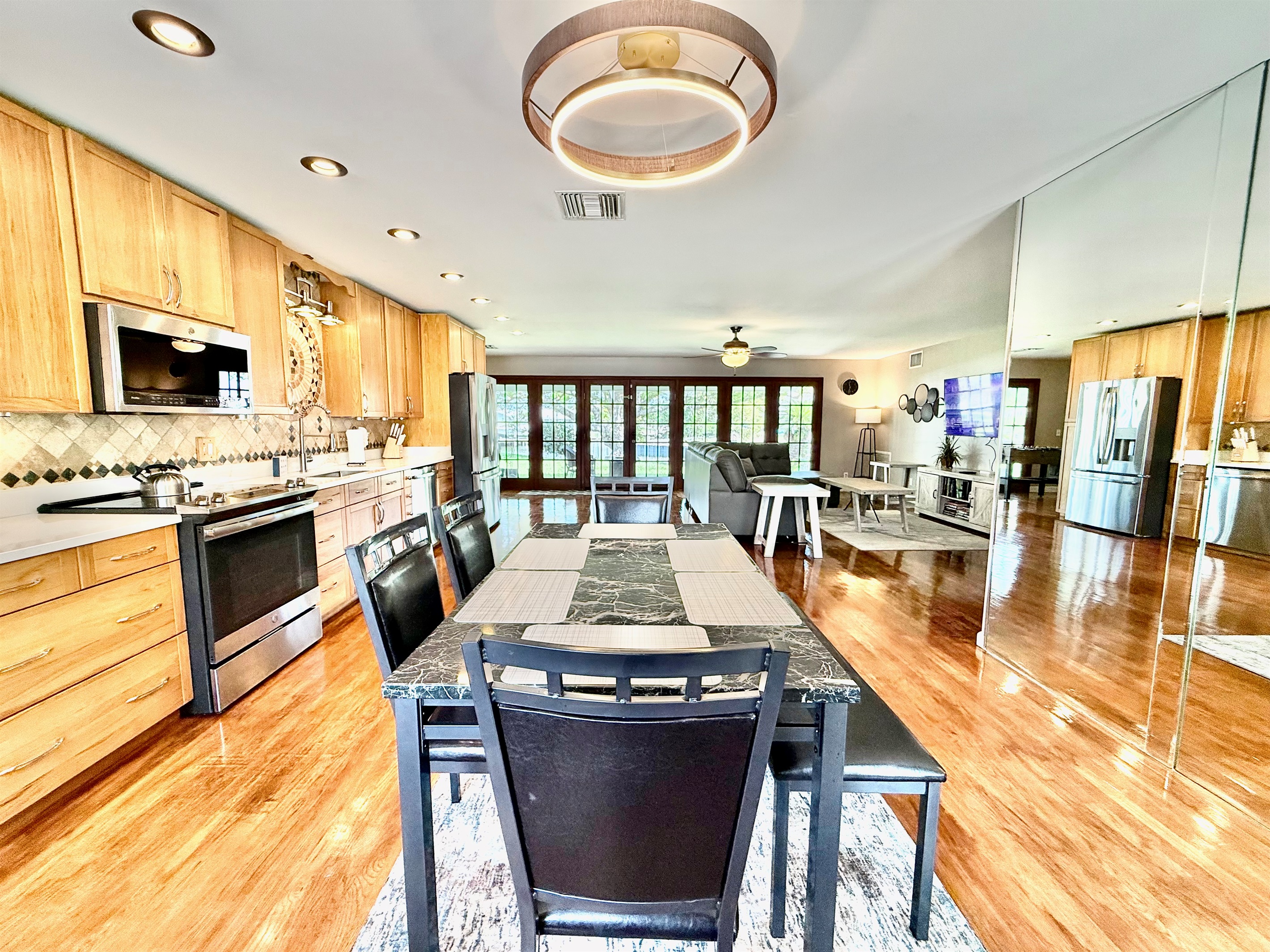 Share stories, laughs, and delicious meals at this sleek dining table, set in the heart of the home and surrounded by warm wood tones and modern lighting.