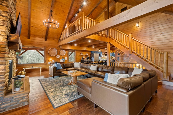 Open-Concept Living Room with Fireplace, Loft Views, and Seating for the Whole Group.