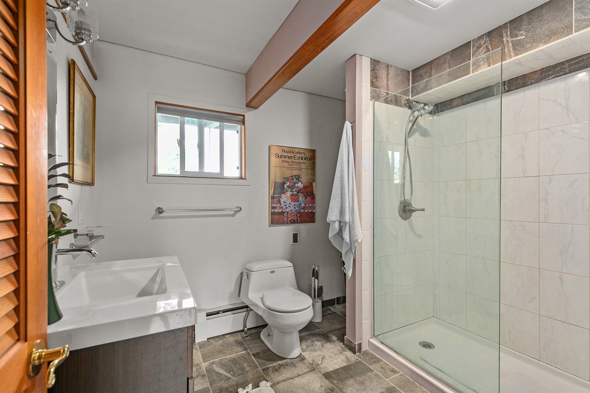 Complete with its own en-suite bathroom featuring a sleek glass walk-in shower, this space blends comfort and modern style for the ultimate private escape.