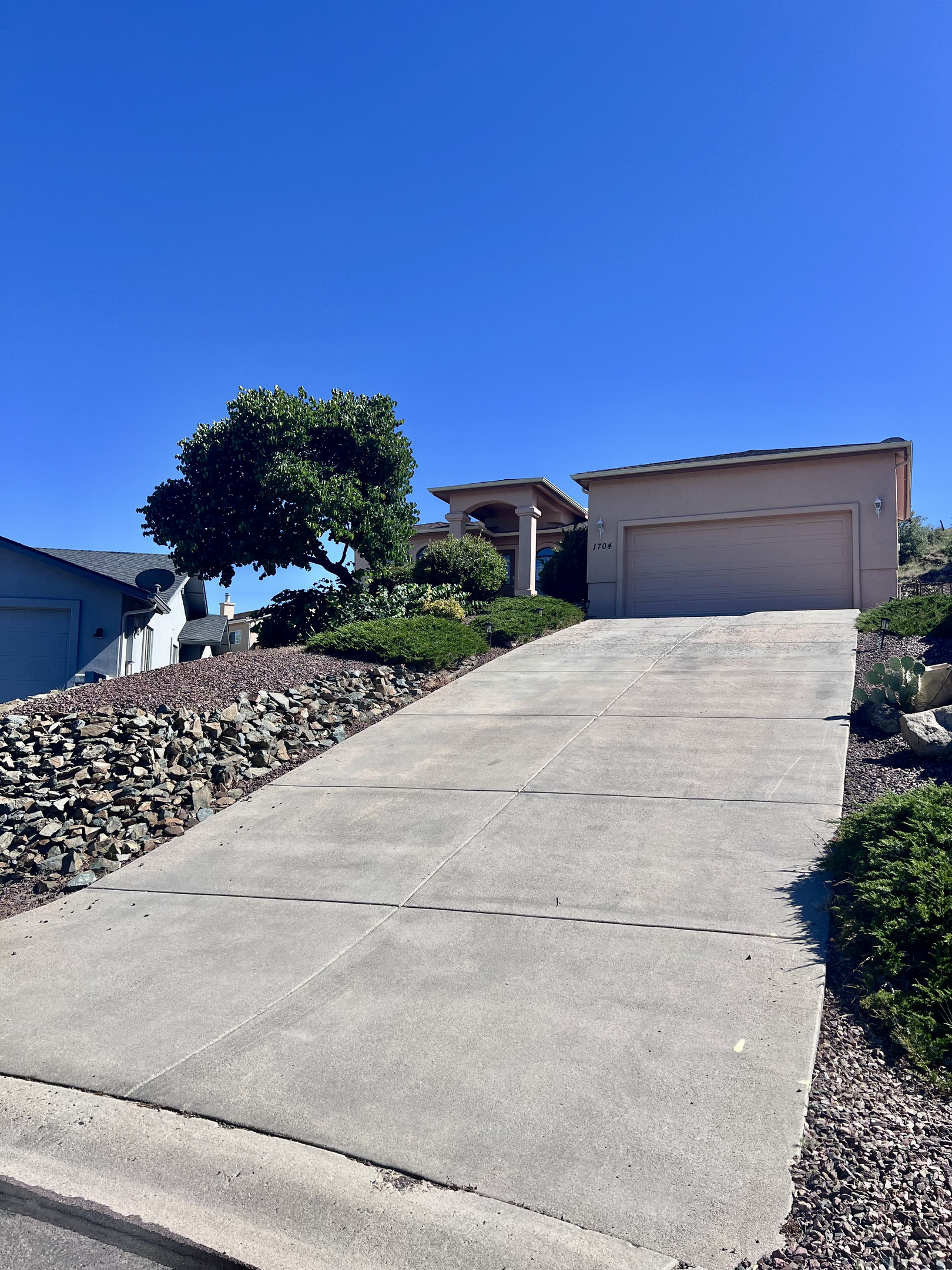 The exterior of the home exudes a sense of welcome and belonging. The well-lit driveway and garage entrance provide a convenient and safe arrival experience