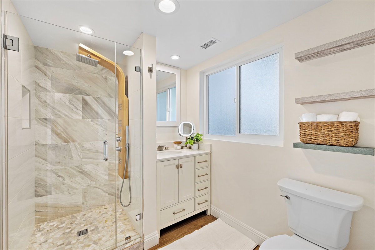 Indulge in a spa-like experience with this elegant walk-in shower and custom tilework.