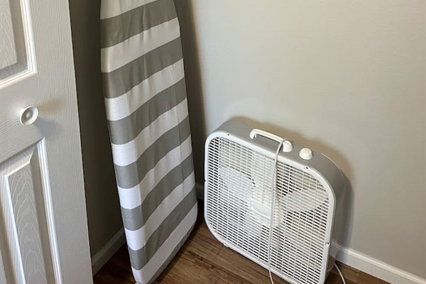 Ironing board, iron and fan. 