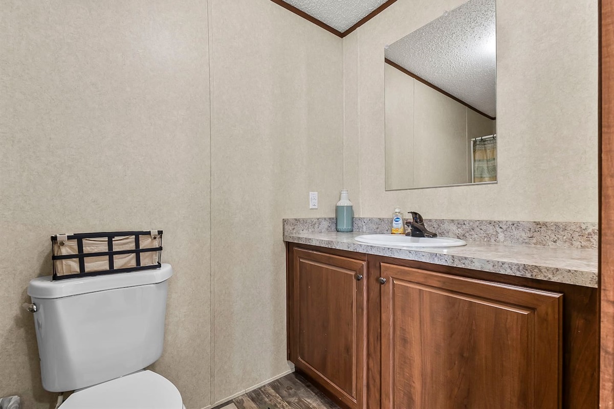 Clean and functional bathroom with a spacious vanity, large mirror, and ample counter space for your daily routine.
