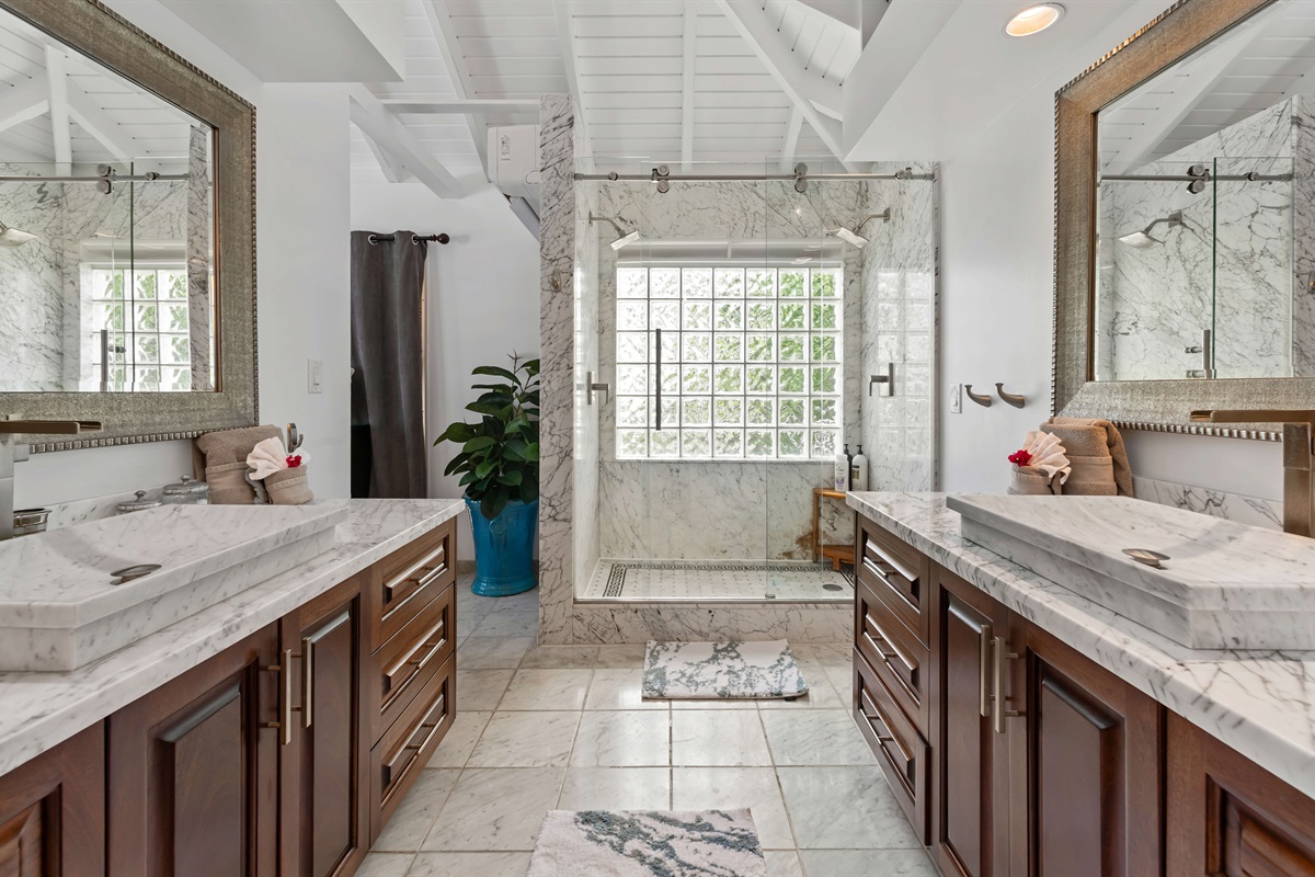 The primary ensuite bathroom with double vanities, marble shower and large closet.