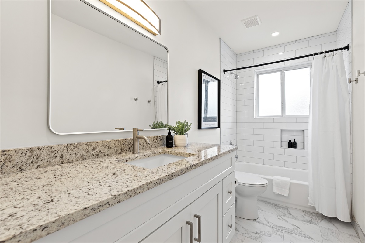 Freshly renovated bathroom with shower/tub combo and clean, modern finishes.