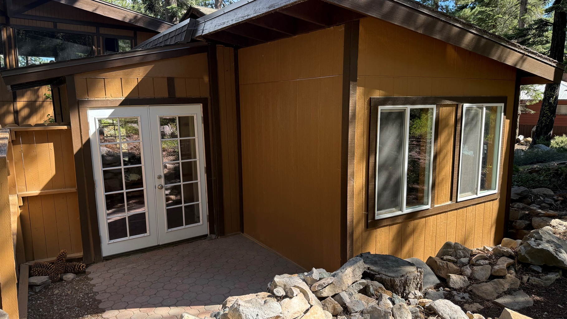 nviting entryway with French doors leading into your private North Lake Tahoe retreat, surrounded by natural rock landscaping and mountain charm