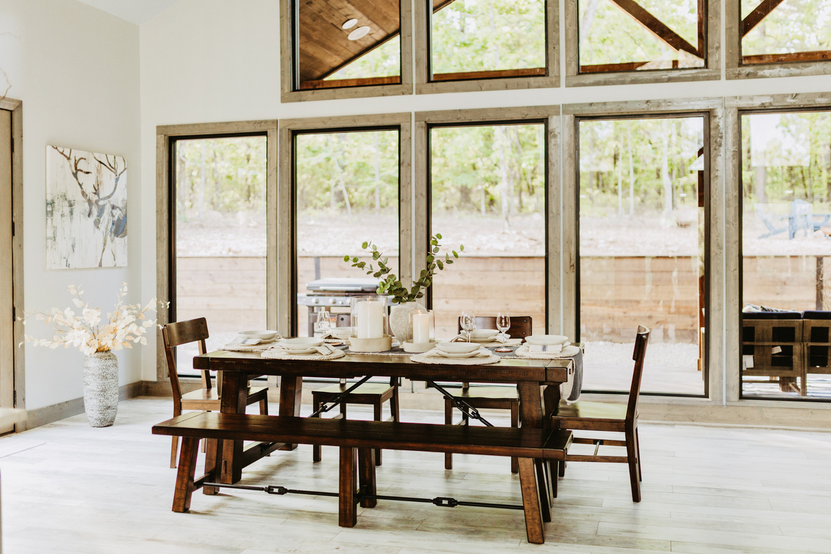 Dining area with large windows and views of the woods.