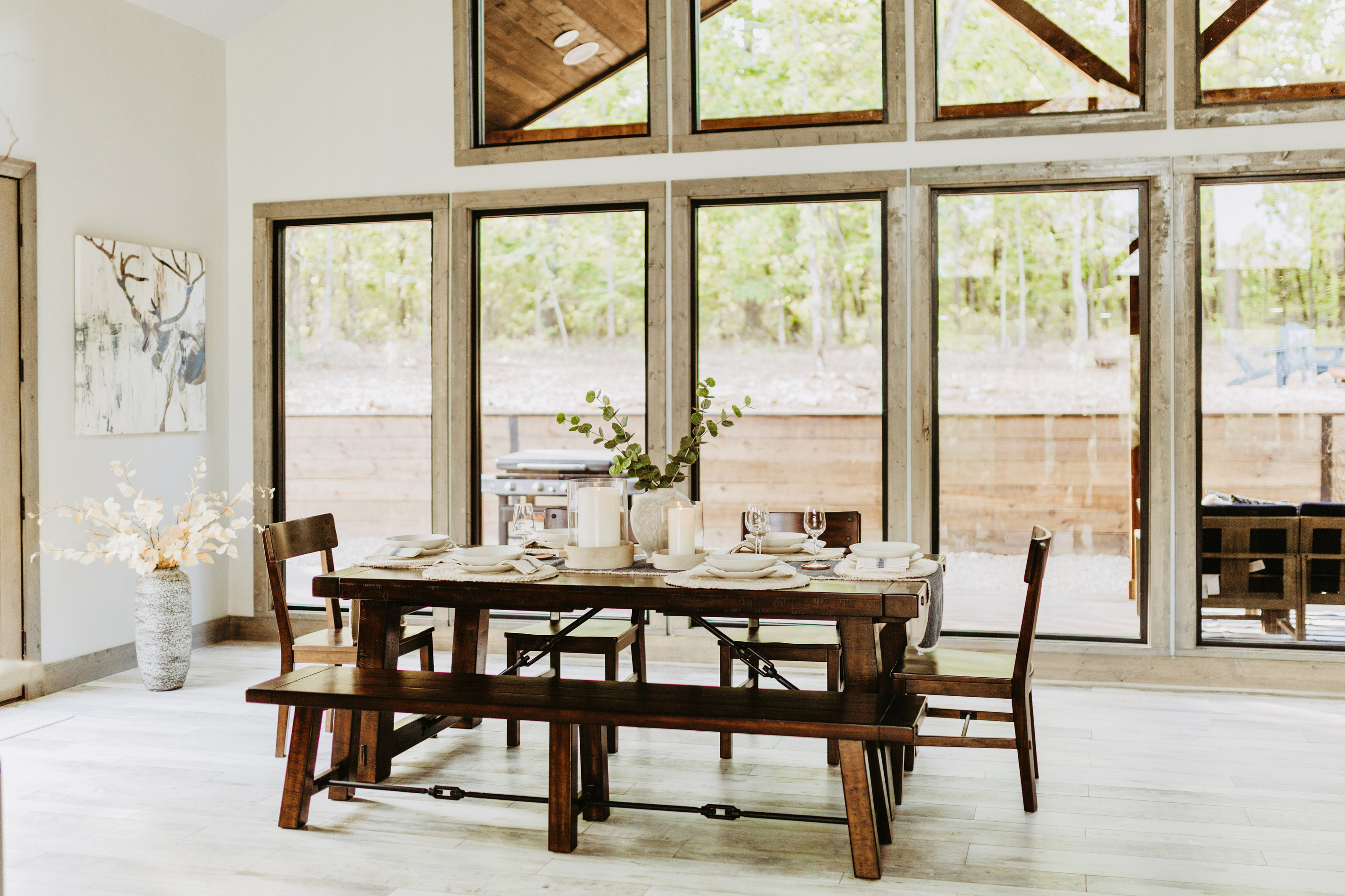 Dining area with large windows and views of the woods.