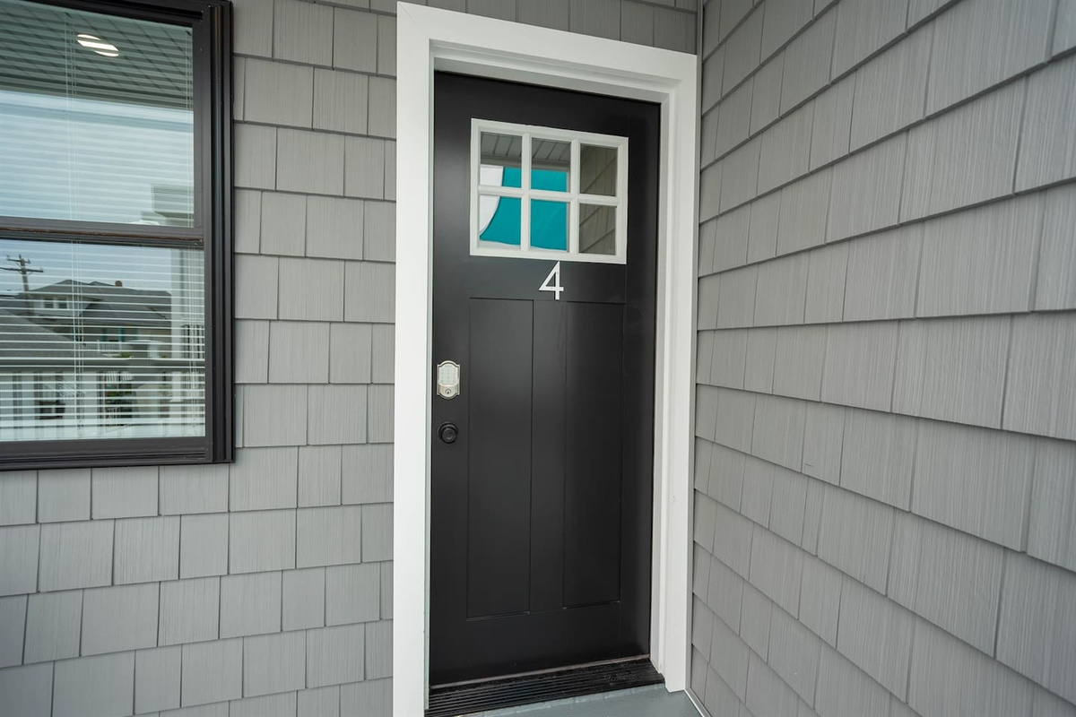 Clean, modern private entrance with a solid black door, secure keypad access, and clear unit numbering. Easy self check-in and direct access to the space create a smooth arrival after travel, with sheltered entry for added comfort.