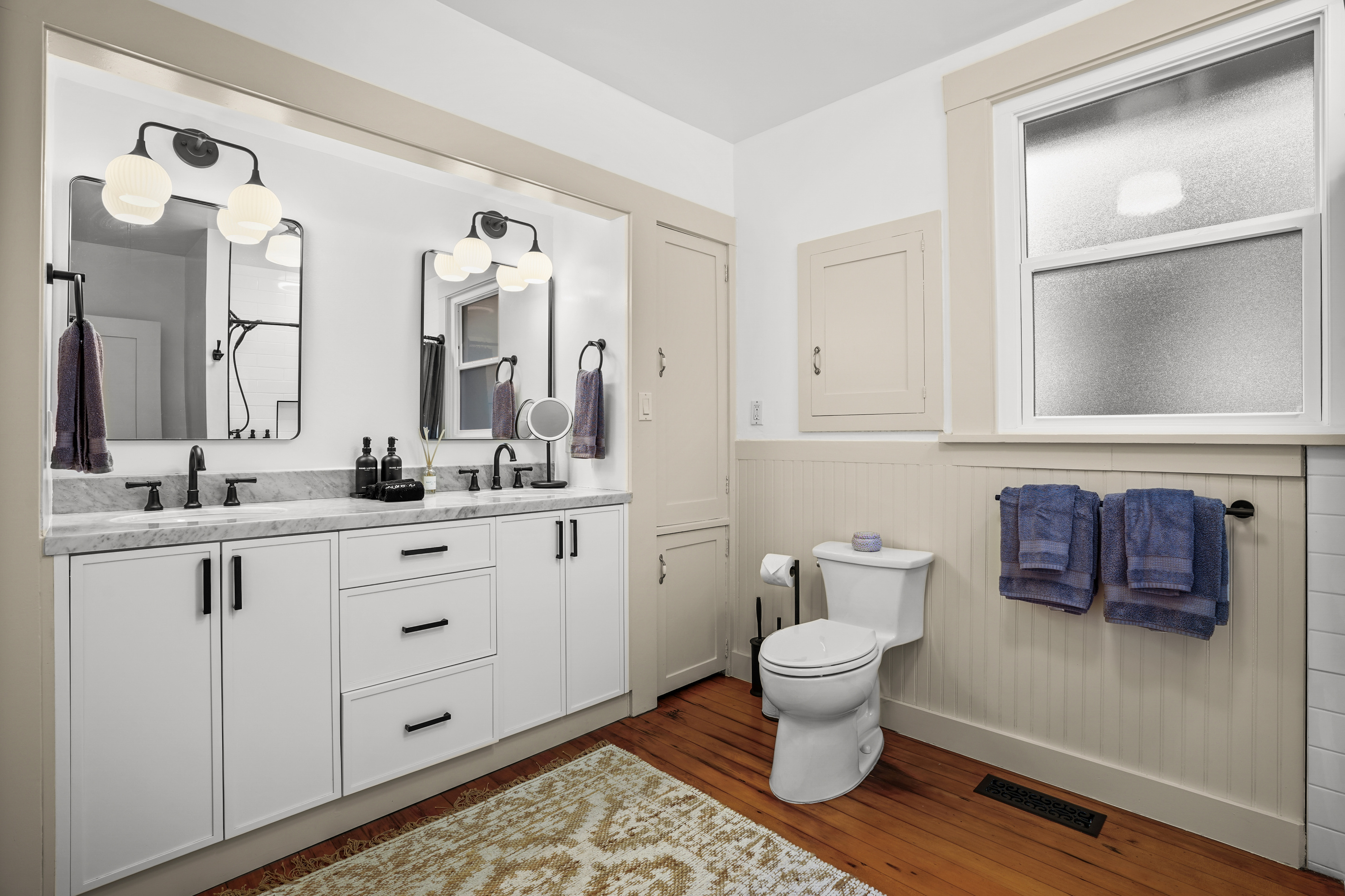 The newly renovated full bathroom downstairs features a double vanity and a bathtub, offering a bright, modern space that's perfect for getting ready or unwinding after a day of exploring Napa Valley.