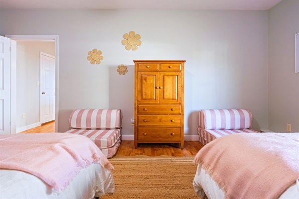 The first bedroom in the basement is perfect for your stay, with two queen beds and two twin beds—comfort and space for all!