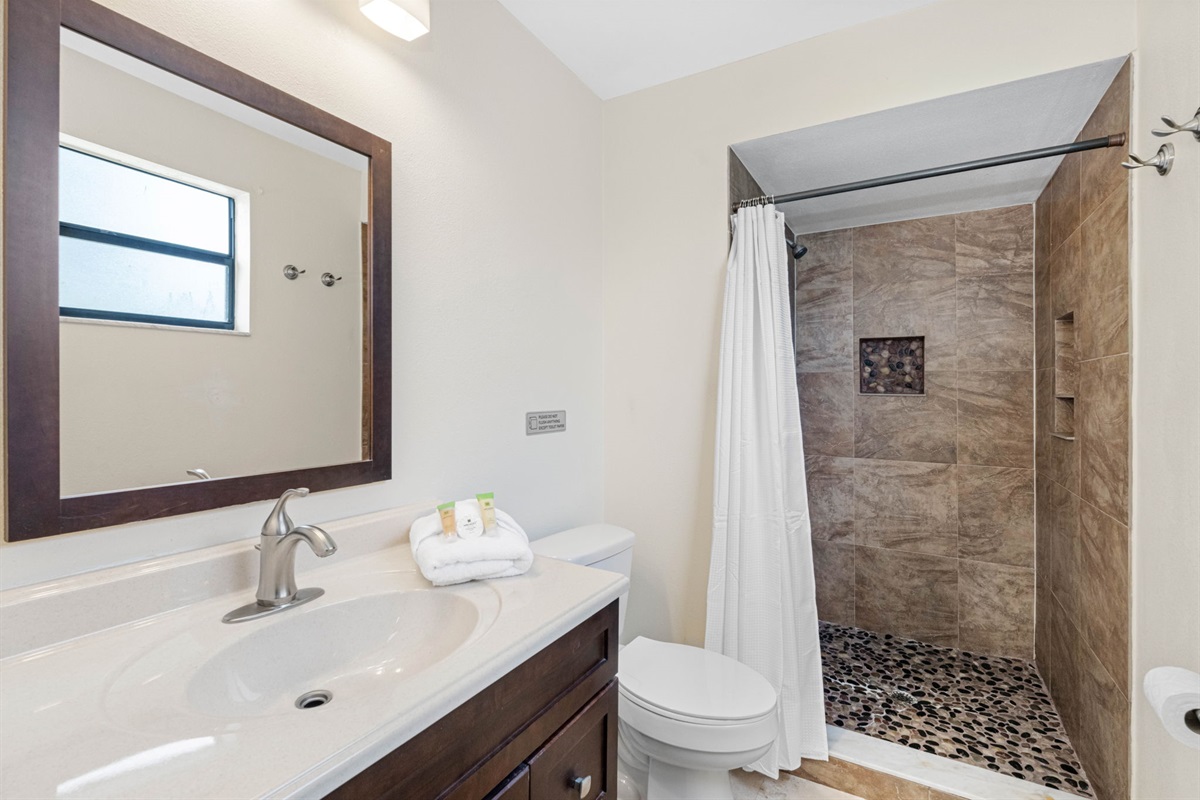 This stylish and well-appointed bathroom combines functional design with warm, earthy aesthetics, creating a calming space for freshening up or winding down.