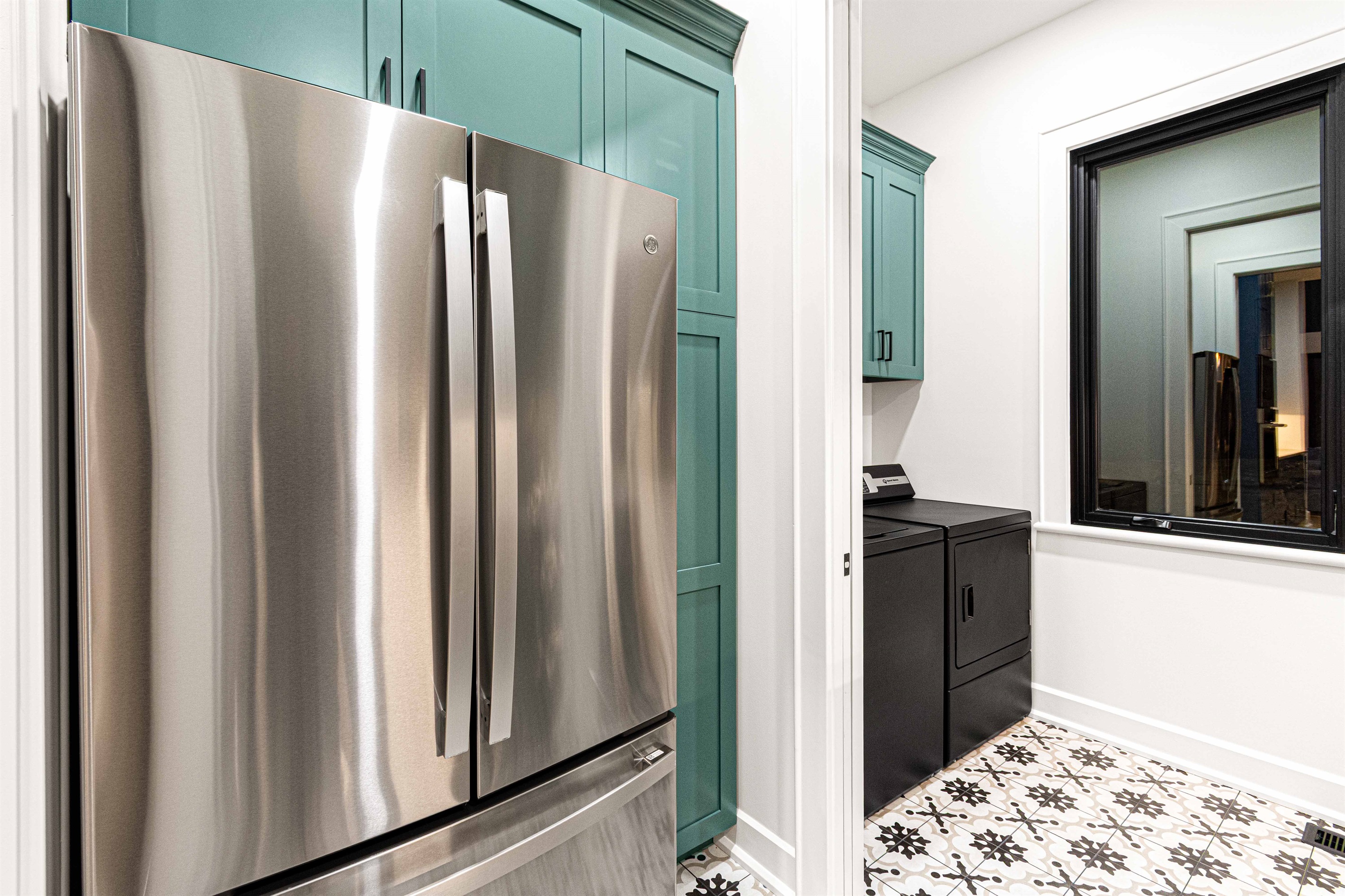 Main level pantry with refrigerator and laundry room