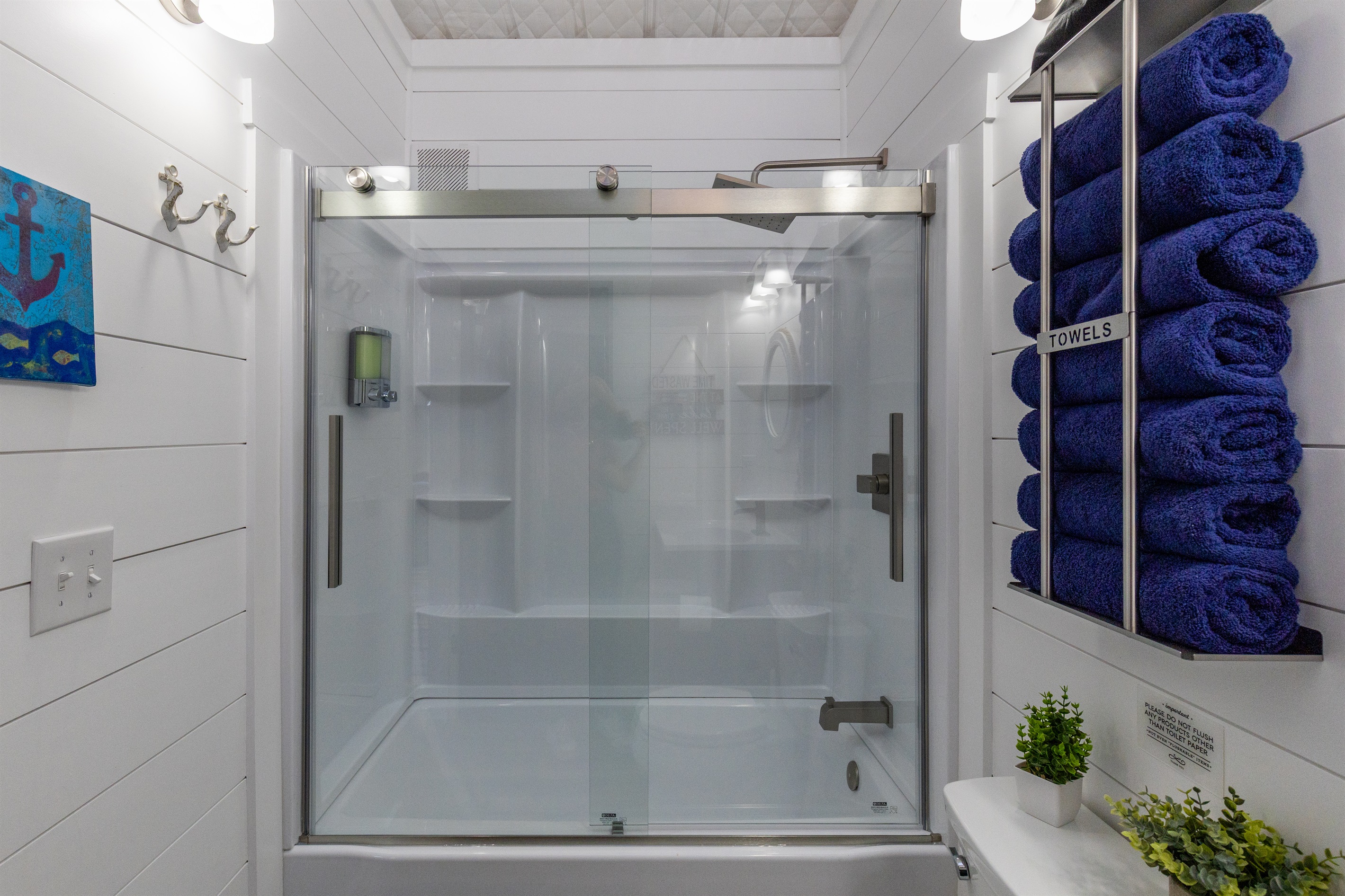 Tub shower with sliding glass doors, rainfall head, and plenty of plush towels for your stay