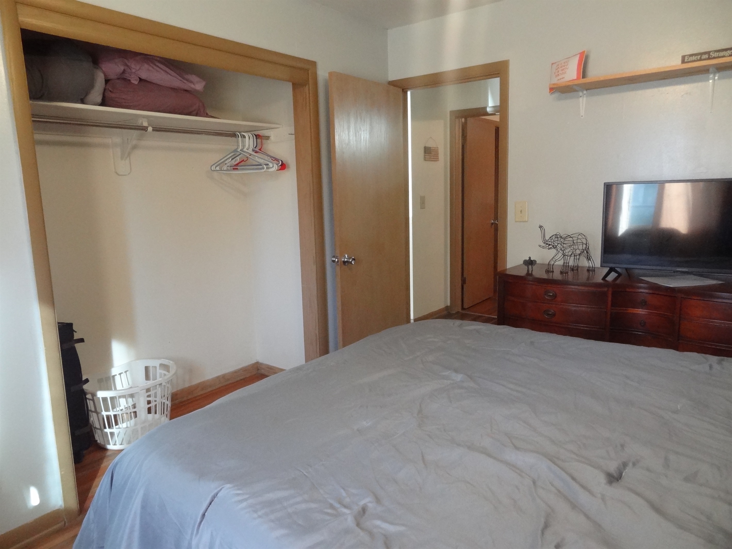 Master bedroom with queen bed, Roku smart TV, dresser, ceiling fan, and desk