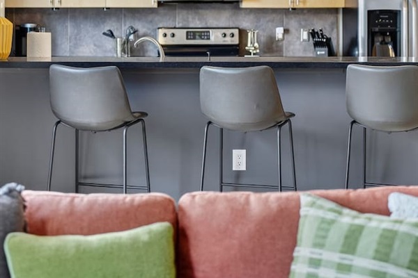 Cook and connect in the open kitchen with stainless steel appliances, sleek bar seating, and designer pendant lighting. Ideal for enjoying coffee, cocktails, or meals together while staying in the heart of downtown Des Moines.