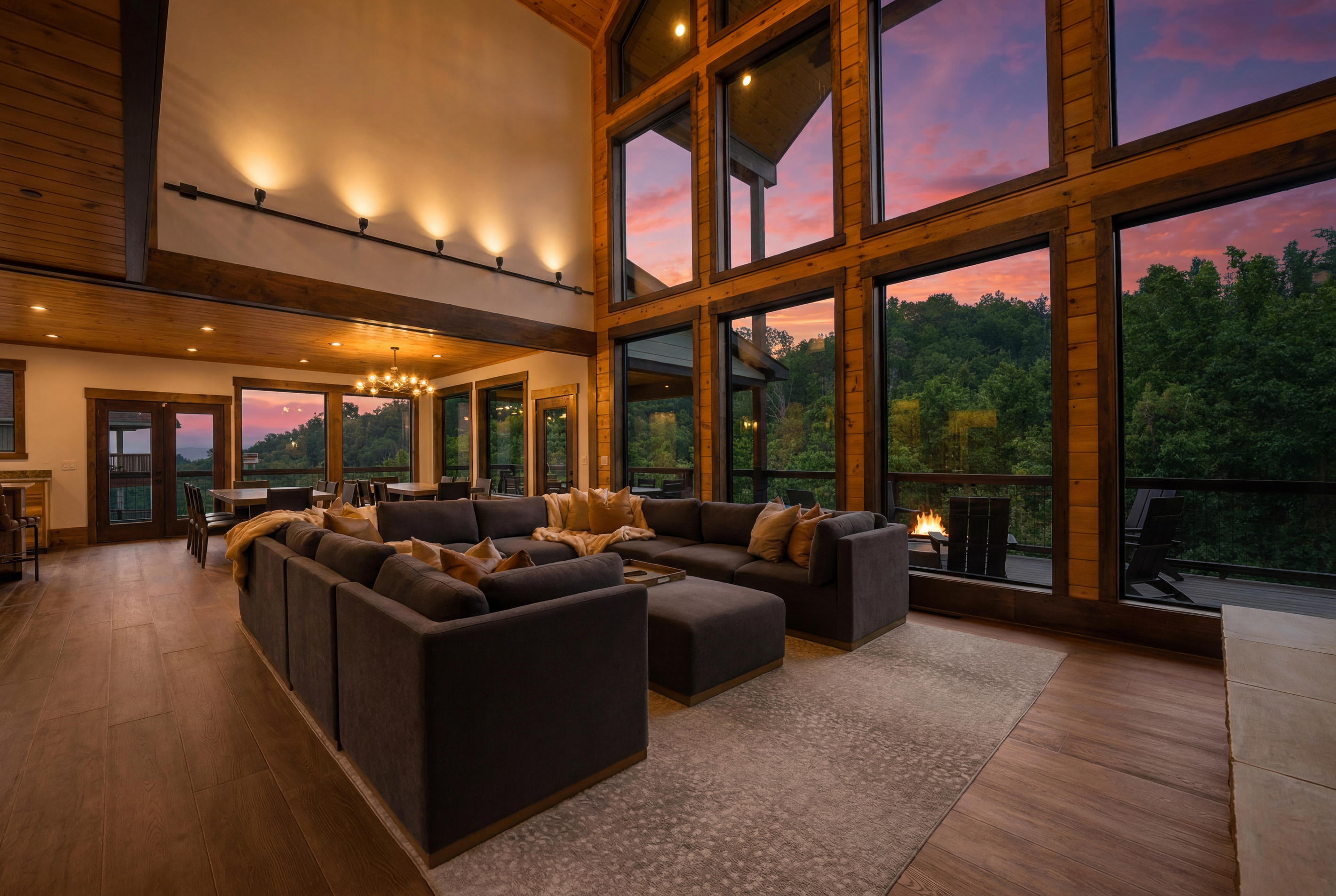 Gather beneath 30-foot vaulted ceilings surrounded by a wall of windows. Relax on the large sectional sofa beside the luxury fireplace with stunning floor-to-ceiling stone, creating a warm and unforgettable mountain lodge atmosphere.