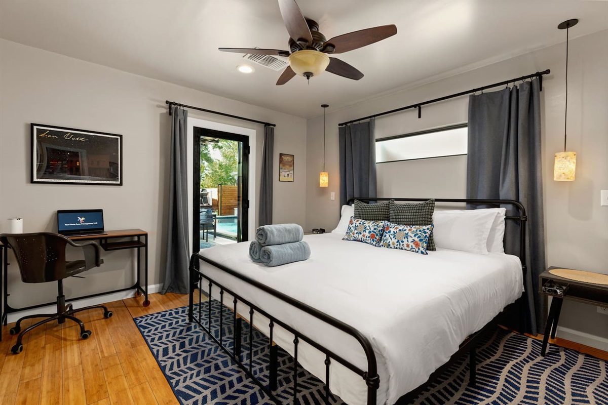 Primary King suite with ensuite bath & private patio access for restful comfort steps from the pool.